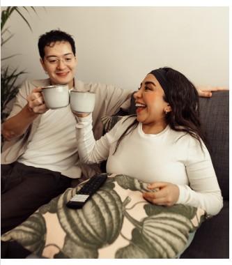 An image of a female carers holding hands with a young lady in a chair 