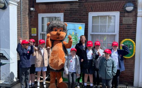 Children outside a school with a banner saying Beat the Street 